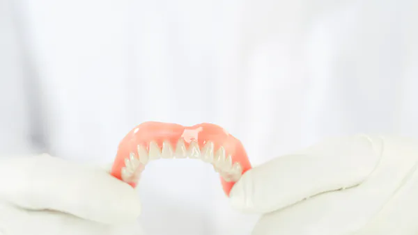 dentist holding removable dentures