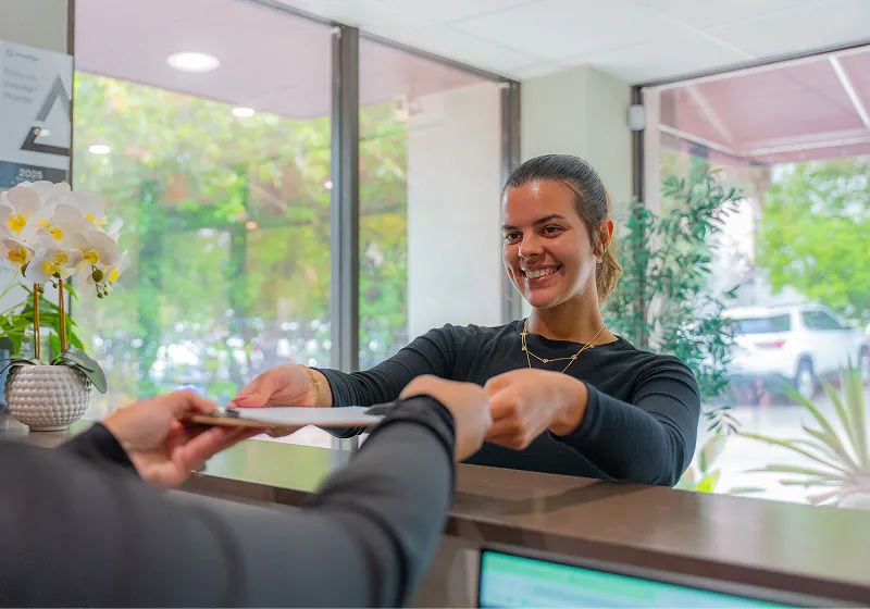 woman turning in her new patient information packet at Lake Lucerne Cosmetic and Implant Dentistry